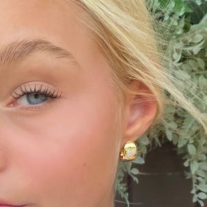 Massete “huggie” wide hoop earrings.